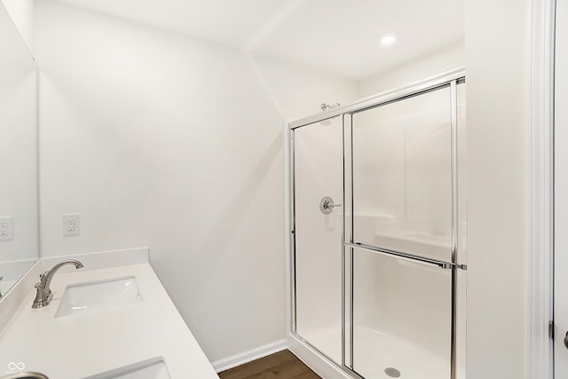 bathroom with vanity, a shower with shower door, and wood-type flooring