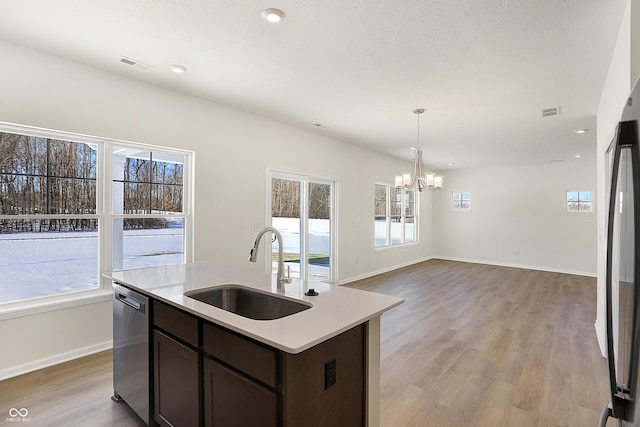 kitchen featuring dark brown cabinets, sink, decorative light fixtures, light hardwood / wood-style flooring, and dishwasher