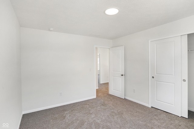 unfurnished bedroom featuring light carpet and a closet