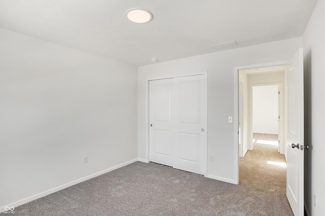 unfurnished bedroom featuring light carpet and a closet