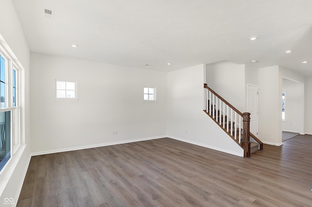 empty room with dark hardwood / wood-style flooring and a healthy amount of sunlight