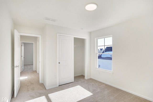 unfurnished bedroom with light carpet and a closet