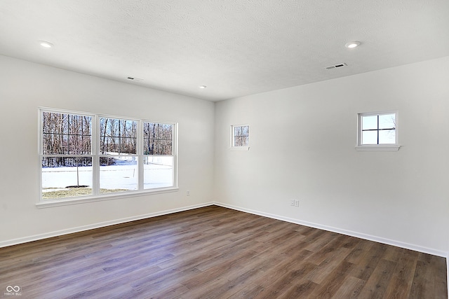 unfurnished room featuring a textured ceiling and dark hardwood / wood-style flooring