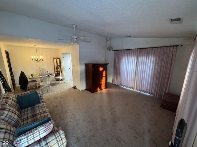 unfurnished living room featuring carpet flooring, a textured ceiling, ceiling fan with notable chandelier, and vaulted ceiling