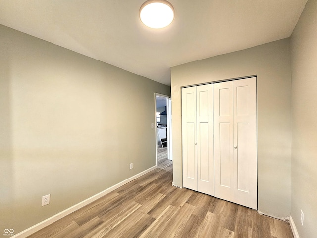 unfurnished bedroom featuring a closet and light hardwood / wood-style floors