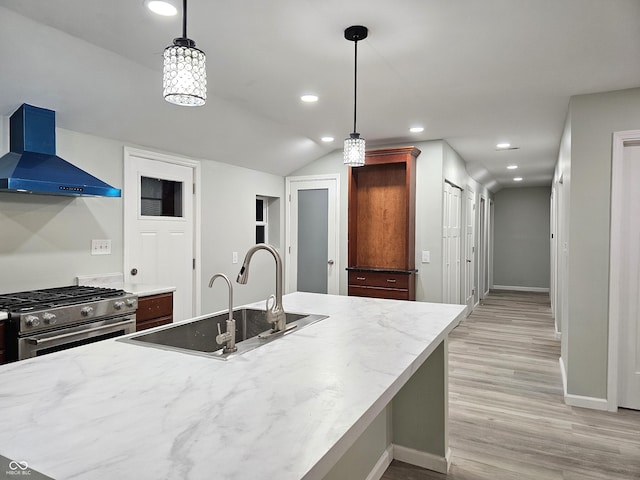 kitchen with high end stainless steel range oven, decorative light fixtures, sink, and extractor fan