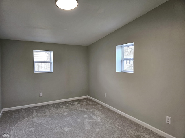 spare room with lofted ceiling and carpet flooring