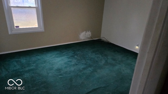 spare room featuring dark carpet