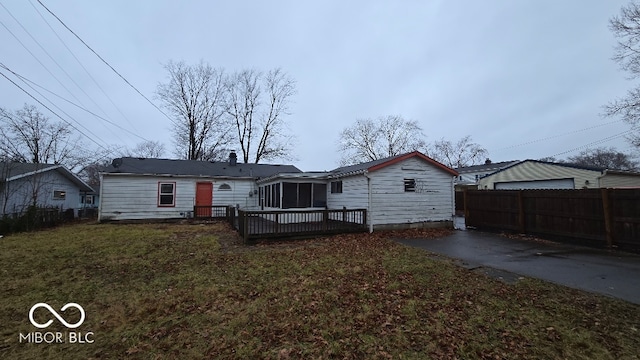 back of house featuring a sunroom, a yard, and a wooden deck