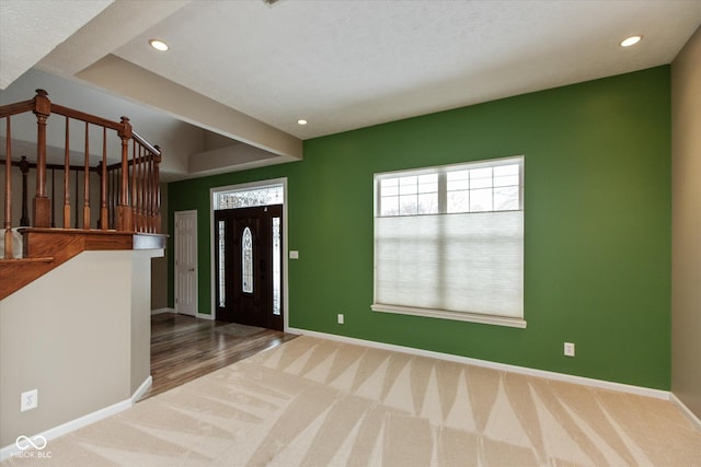 carpeted foyer featuring a textured ceiling