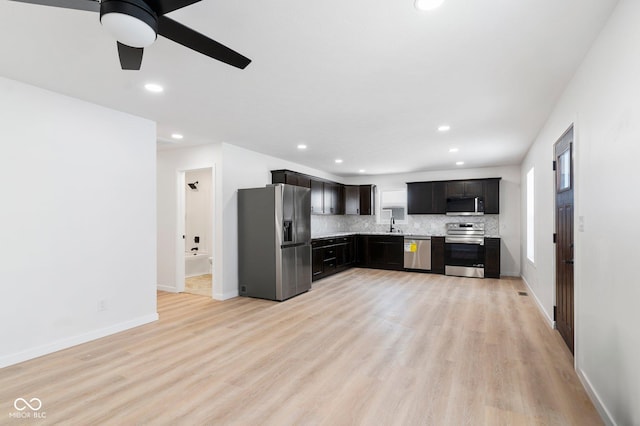 kitchen with appliances with stainless steel finishes, light wood-type flooring, tasteful backsplash, and ceiling fan