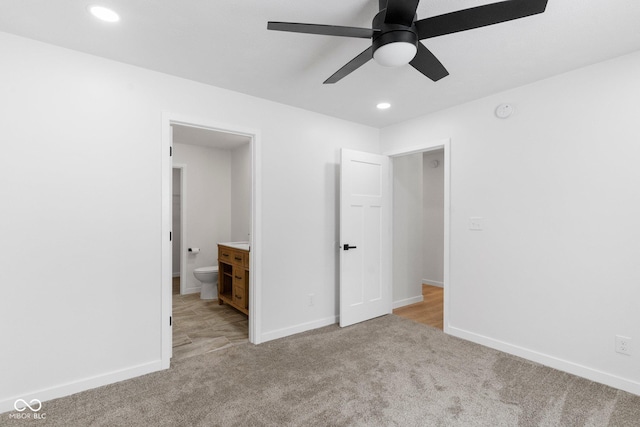 unfurnished bedroom featuring ensuite bathroom, ceiling fan, and light colored carpet