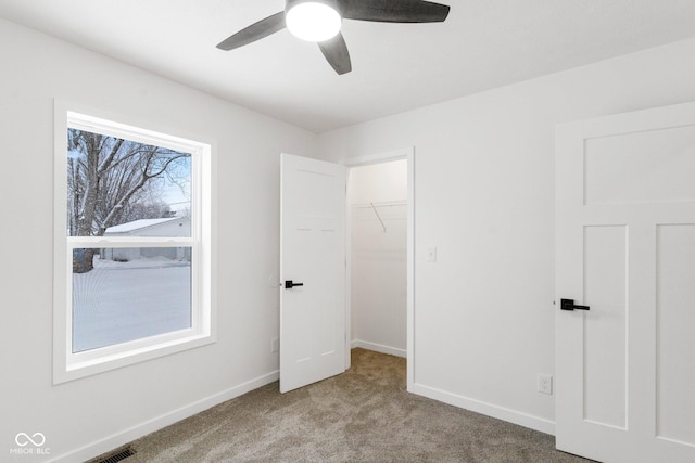 unfurnished bedroom with multiple windows, ceiling fan, a closet, and light carpet