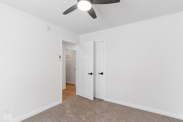 unfurnished bedroom with a closet, light colored carpet, and ceiling fan