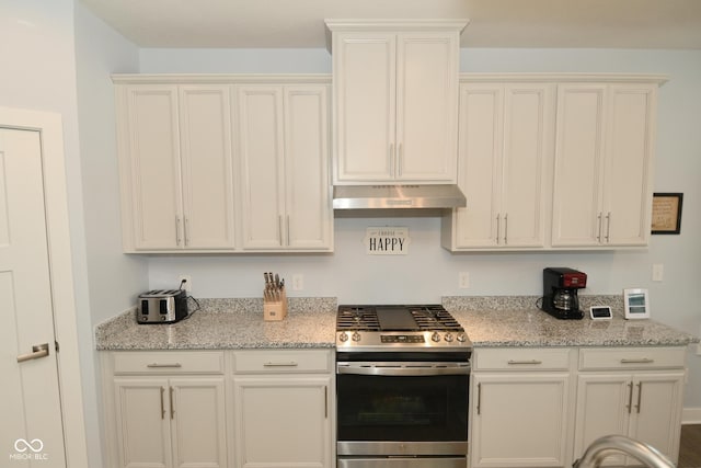 kitchen featuring white cabinets, light stone counters, and stainless steel range oven