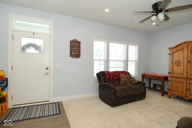 carpeted entrance foyer featuring ceiling fan and a wealth of natural light