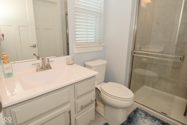 bathroom featuring vanity, toilet, and an enclosed shower