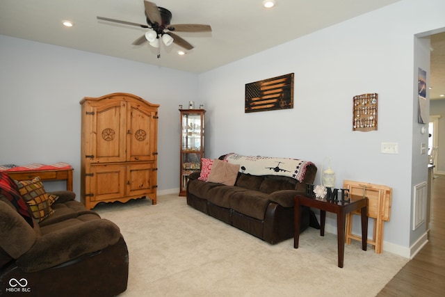 carpeted living room with ceiling fan