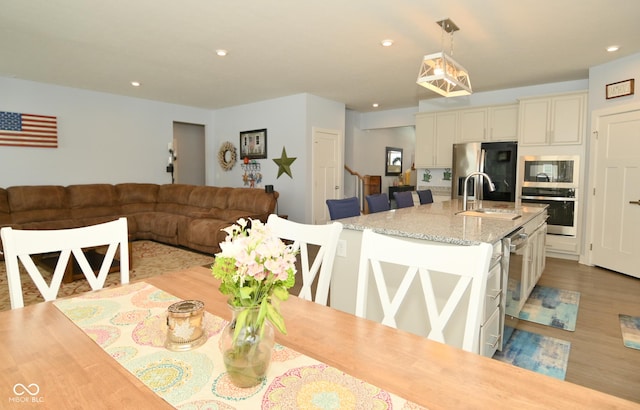 dining area featuring light wood-type flooring and sink