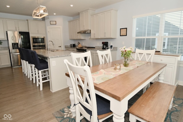 dining room with sink and light wood-type flooring