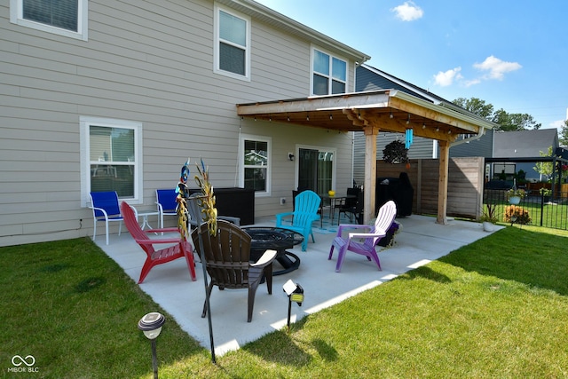 rear view of house with a fire pit, a patio area, and a lawn