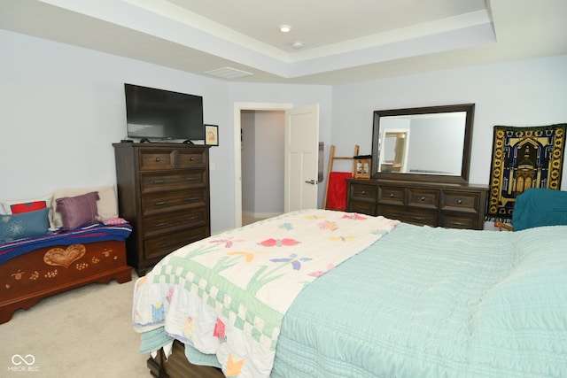 bedroom with light carpet and a raised ceiling