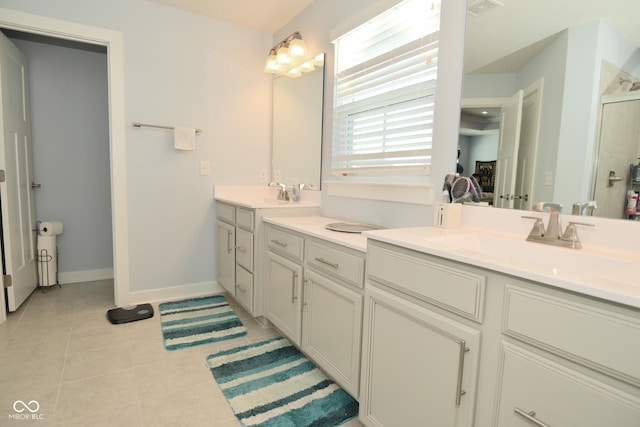 bathroom with tile patterned flooring, vanity, and walk in shower