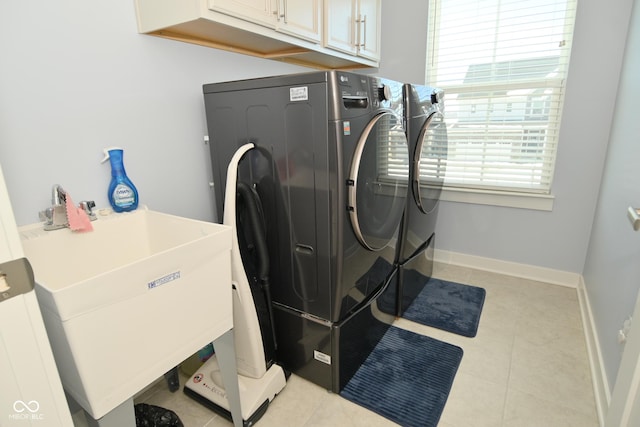 washroom featuring cabinets, light tile patterned flooring, washing machine and dryer, and sink