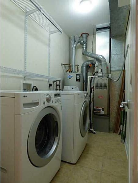 laundry area featuring water heater and washer and clothes dryer