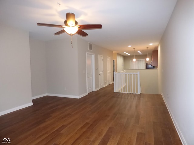 empty room with dark hardwood / wood-style floors and ceiling fan