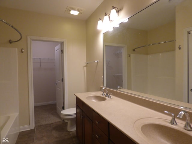 bathroom with toilet, vanity, and tile patterned floors