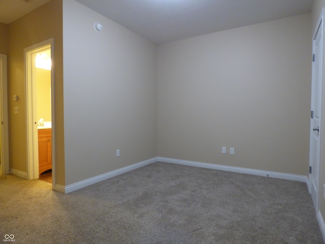 unfurnished bedroom featuring ensuite bath and light carpet