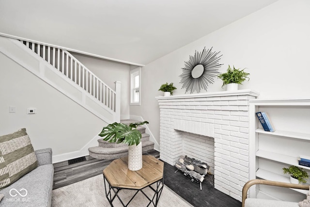 living room featuring hardwood / wood-style floors and a brick fireplace