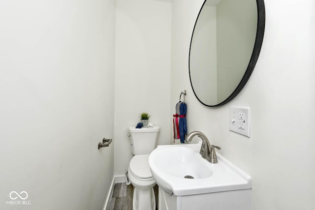 bathroom with hardwood / wood-style flooring, toilet, and sink