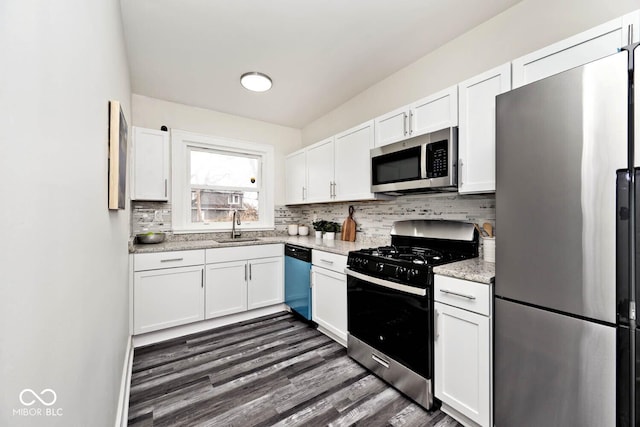 kitchen featuring light stone countertops, white cabinetry, sink, and stainless steel appliances