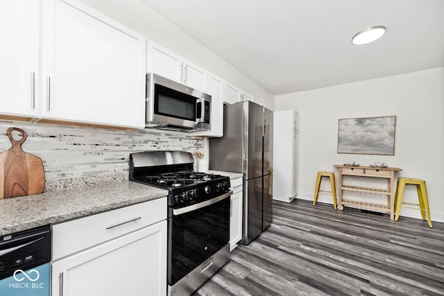 kitchen with decorative backsplash, appliances with stainless steel finishes, light stone counters, dark wood-type flooring, and white cabinets