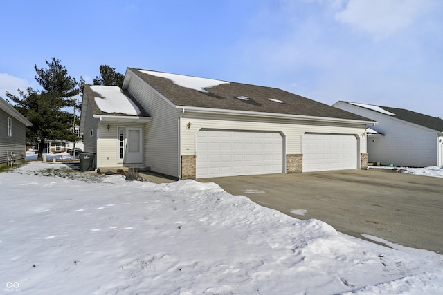 snow covered property with a garage