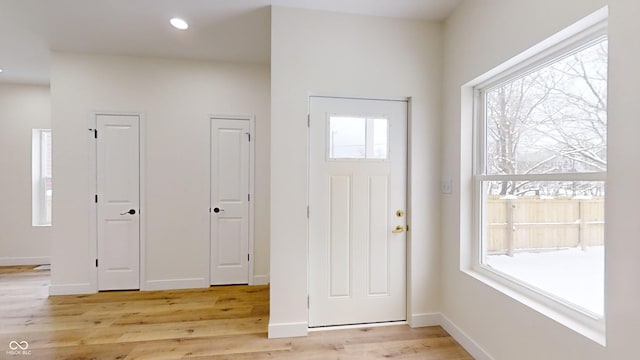 foyer entrance with light hardwood / wood-style floors and a wealth of natural light