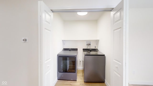 washroom featuring light wood-type flooring and washer and clothes dryer