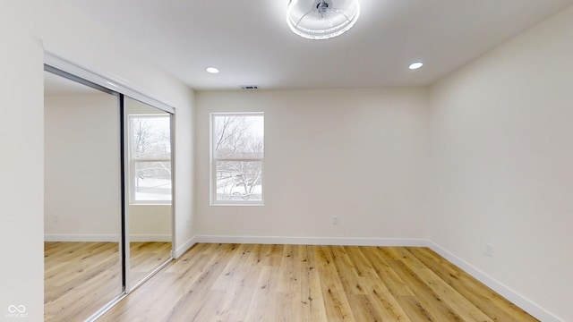 unfurnished bedroom with a closet and light hardwood / wood-style flooring