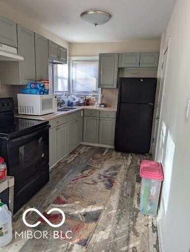 kitchen with black appliances, gray cabinetry, and sink