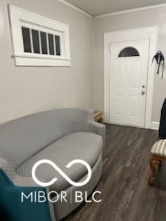 living room with dark hardwood / wood-style flooring and ornamental molding