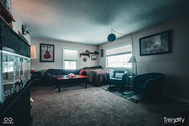 bedroom featuring multiple windows, a textured ceiling, and dark colored carpet