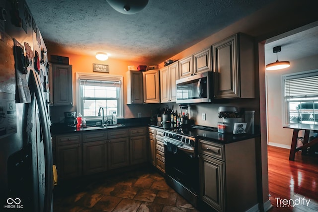 kitchen featuring sink, stainless steel appliances, and a textured ceiling