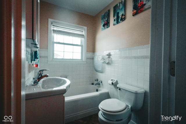 bathroom with a tub, vanity, tile walls, and toilet