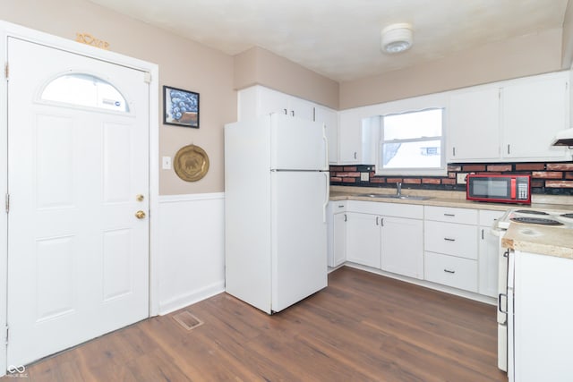 kitchen with white cabinetry, sink, white appliances, and tasteful backsplash