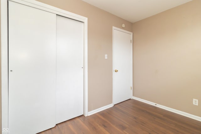 unfurnished bedroom featuring dark hardwood / wood-style floors and a closet