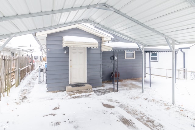 snow covered structure with a carport