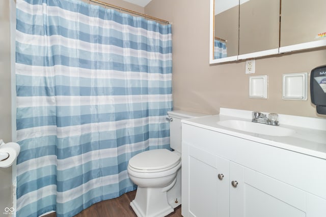 bathroom featuring toilet, vanity, and hardwood / wood-style floors