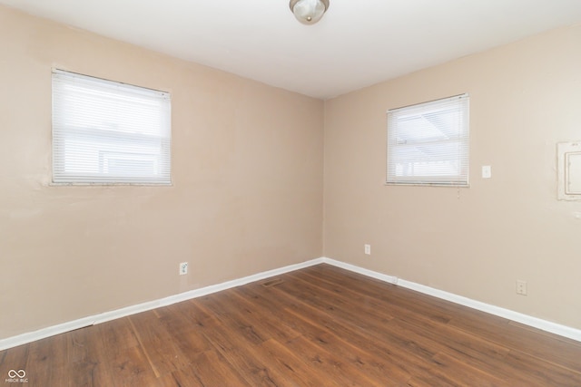 unfurnished room with plenty of natural light and dark hardwood / wood-style flooring